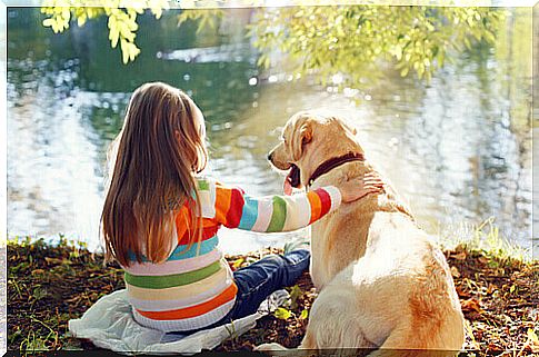 girl with dog in front of lake